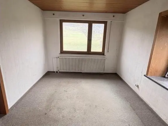 Leergeräumtes Wohnzimmer nach der Entrümpelung, besenrein zur Übergabe.