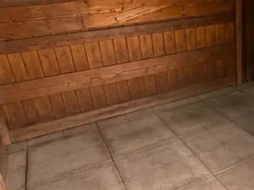 Leergeräumter Geräteschuppen mit gefegtem Fliesenboden.